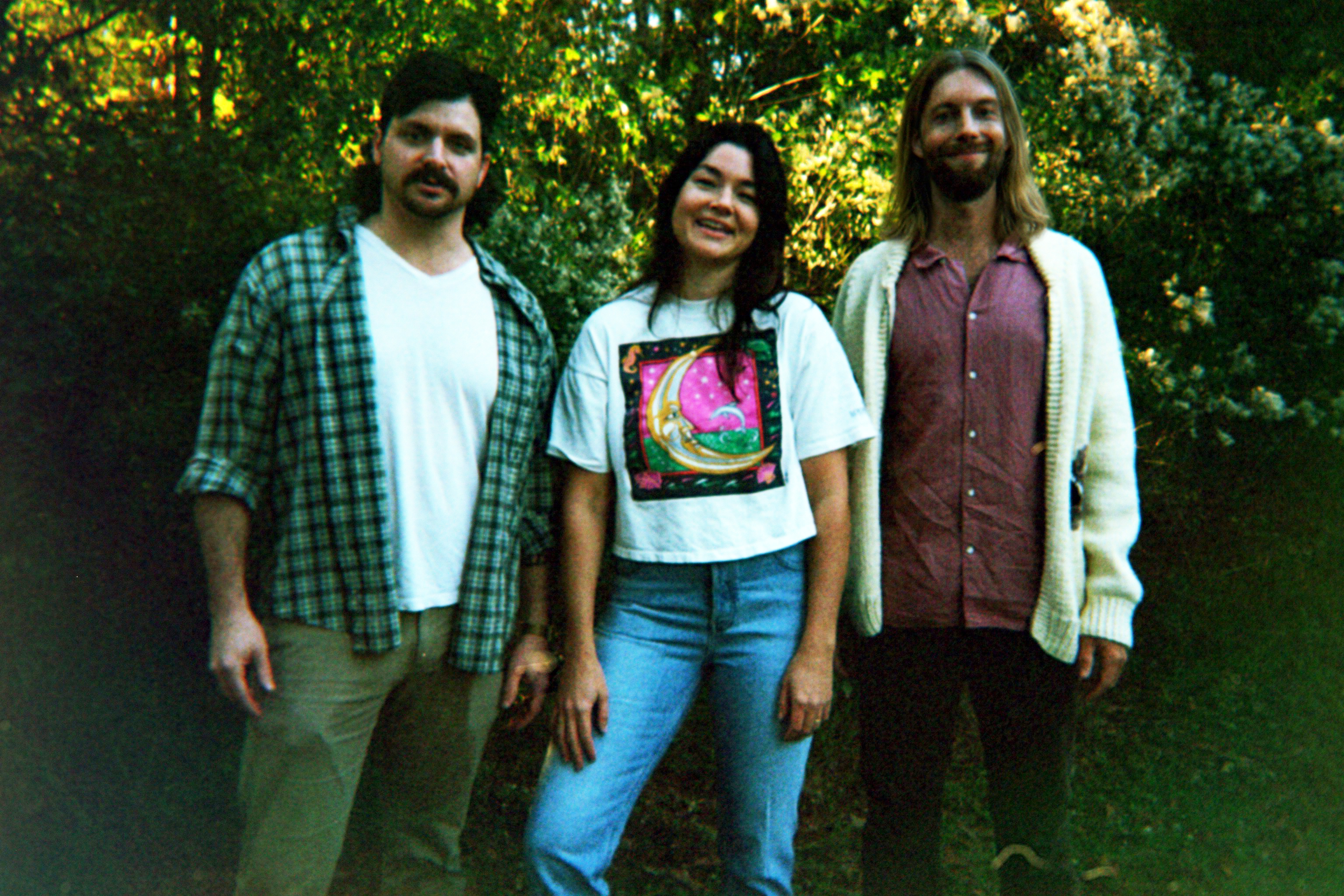 Polaroid photo of the band in front of trees